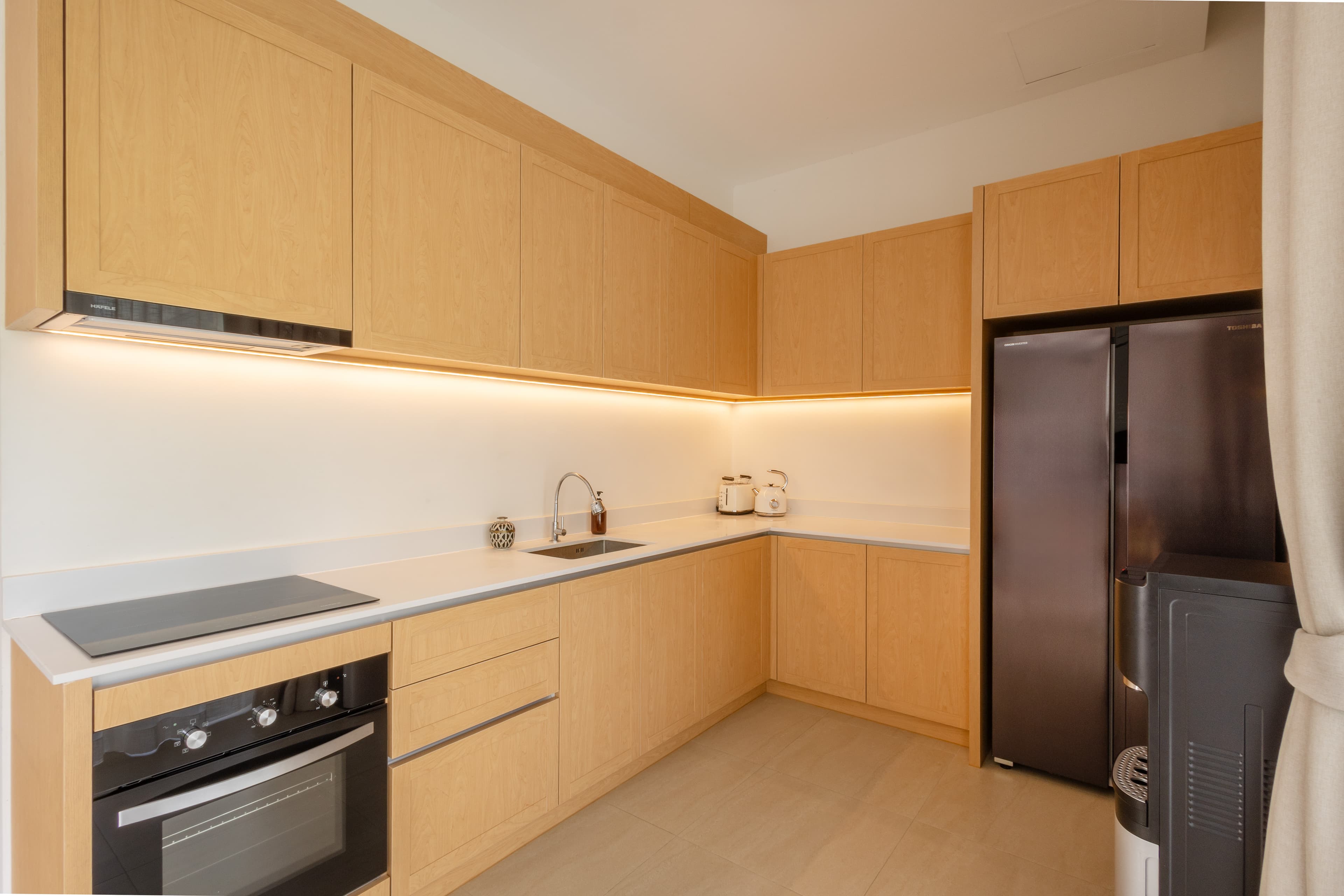 Fully equipped kitchen with light wood cabinetry — Barefoot Villas