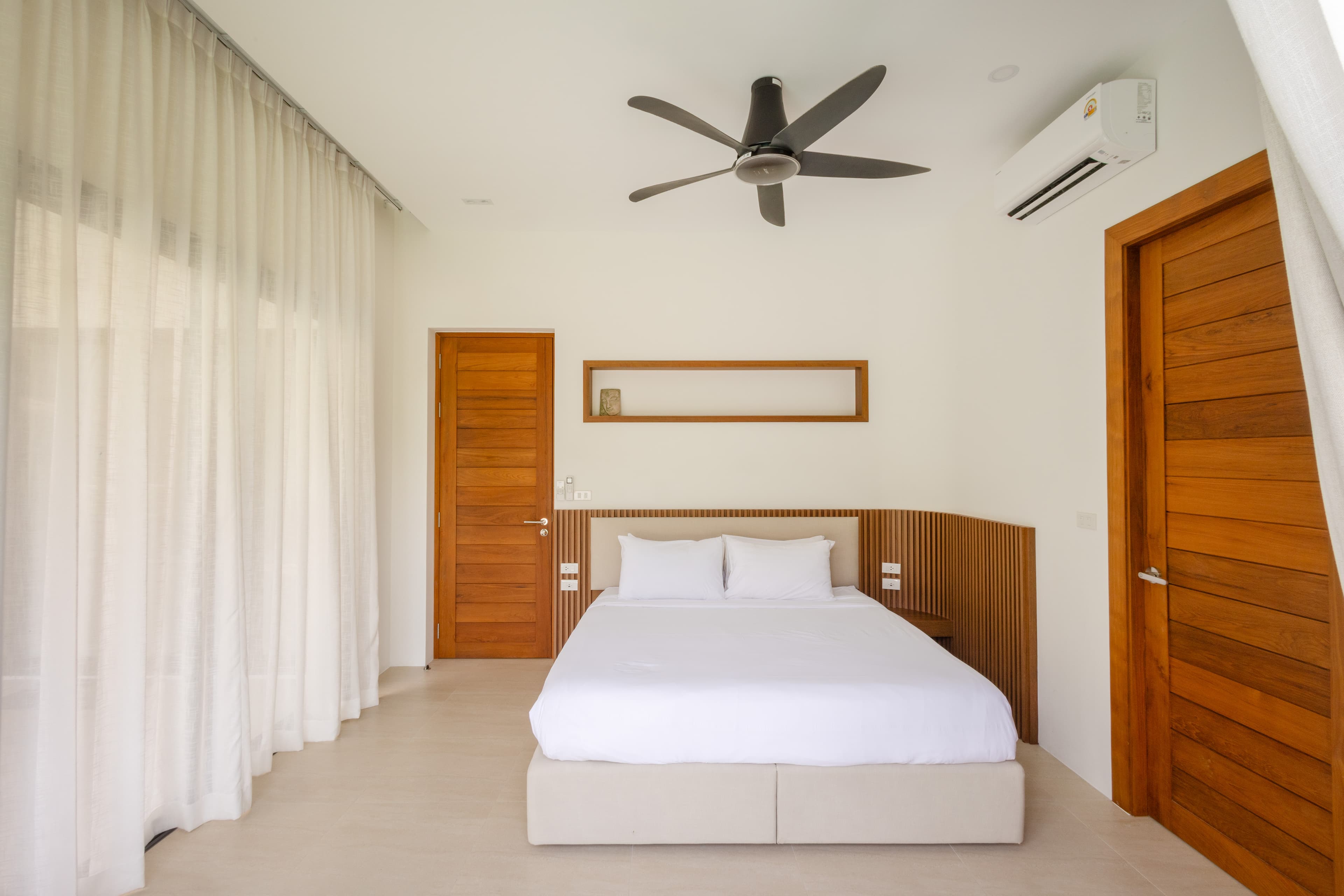 King bedroom with slatted headboard — Barefoot Villas